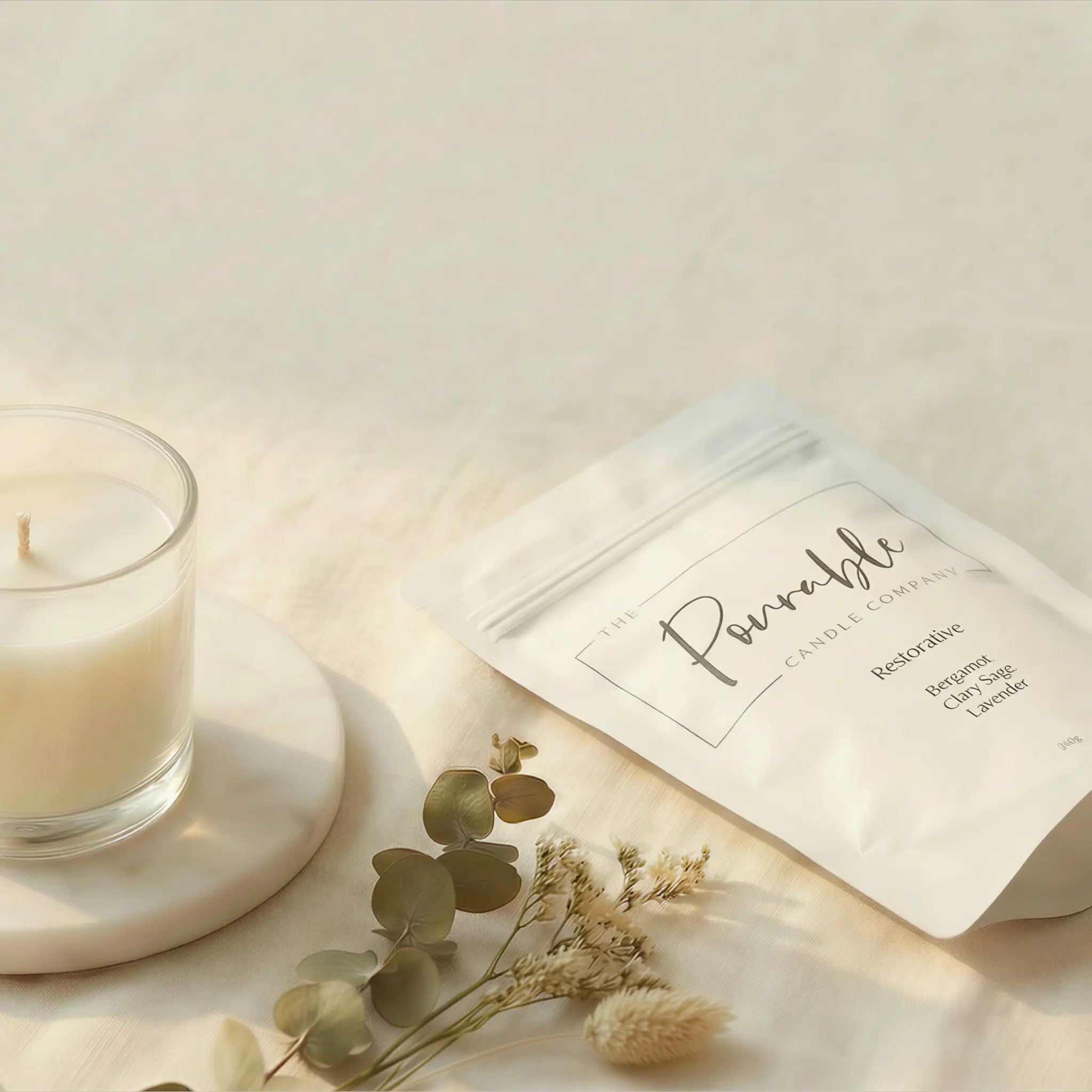 Pourable candle and refill pouch in a warm lifestyle setting
